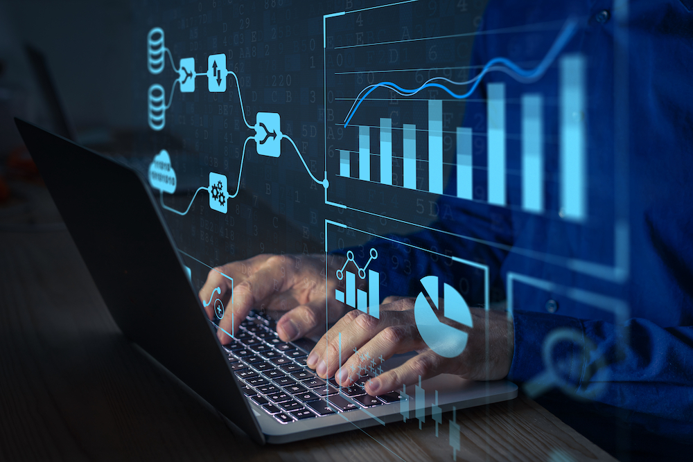 Team member typing on laptop with charts and graphs